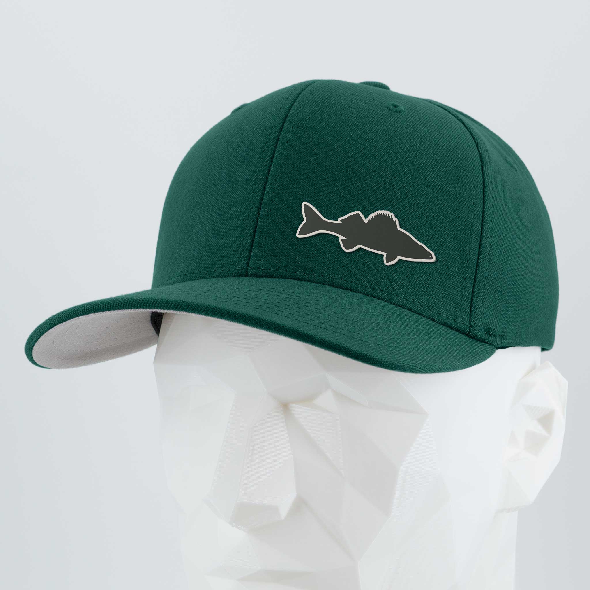 The Eternal Glyph Large Mouth Bass (Silicone) Flexfit® Premium Wool Blend Cap is a dark green flat-brim hat with a bass silhouette patch, shown on a white geometric mannequin head against a plain background.