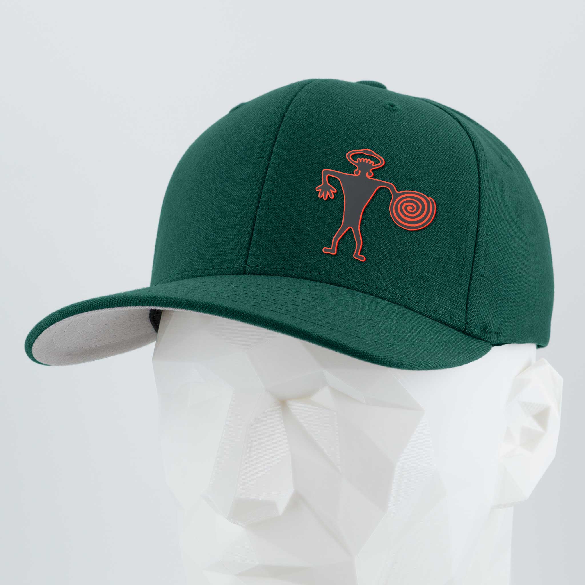 The Eternal Glyph Spiral Warrior Petroglyph Flexfit® Premium Wool Blend Cap in spruce features an orange abstract figure, inspired by Moab’s petroglyph, embroidered on the front and shown on a white mannequin.